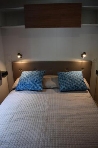 a bedroom with a bed with blue pillows on it at Camping Gabicce Monte in Gabicce Mare