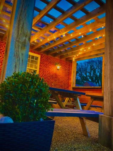 a wooden picnic table sitting under a wooden pergola at The Kings Arms - Fleggburgh in Burgh Saint Margaret