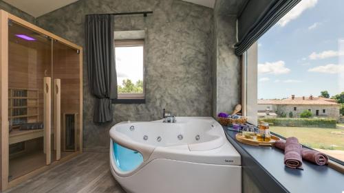 Nova VasにあるVilla Lavanda by Villas Holidayの大きな浴槽と窓のあるバスルーム