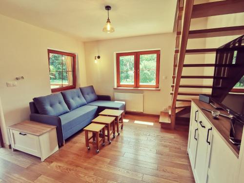 a living room with a blue couch and wooden floors at Zwierzyniec u Kowala in Zwierzyniec