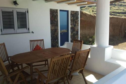 a wooden dining table and chairs on a patio at La casa blu deluxe in Lipari