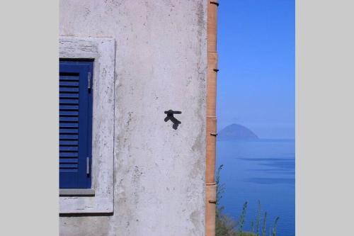 a person climbing up the side of a building next to a window at La casa blu deluxe in Lipari