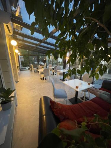 a restaurant with a couch and tables and chairs at Moris Boutique Beach Hotel in Gdańsk