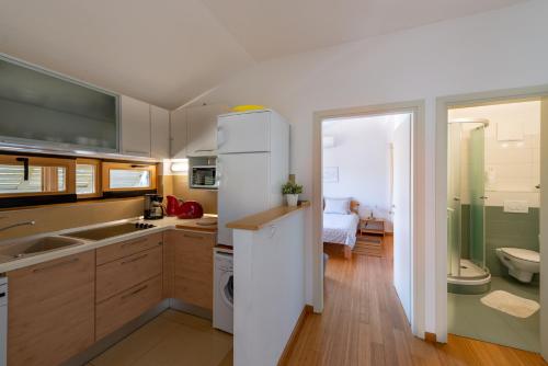 a kitchen with a white refrigerator and a sink at Casa Bamboo in Banjole