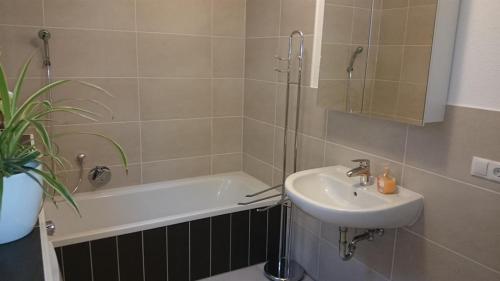a bathroom with a sink and a bath tub at Ferienwohnung Viktoria in Bad Kissingen