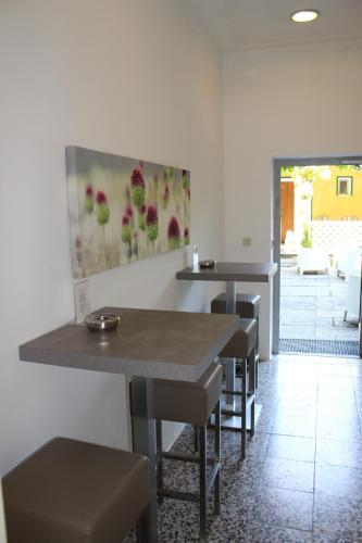 a restaurant with tables and chairs and a painting on the wall at Hotel Michael in Gerasdorf bei Wien