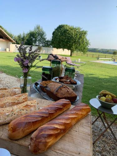 a table with breads and other foods on it at La Gouronerie in Parçay-sur-Vienne