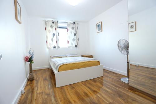 um pequeno quarto com uma cama e uma janela em Lovely View 2 beds 2 bath Apartment, London em North Woolwich