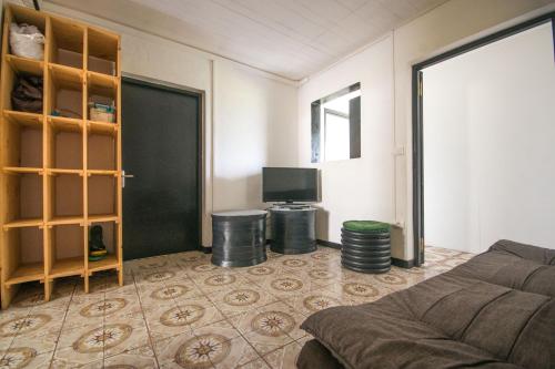 a living room with a couch and a tv at CILAOS 360° in Cilaos