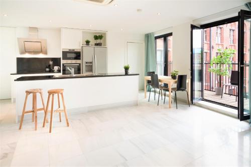 a kitchen and dining room with a counter and chairs at The Antwerp Marble Lodge in Antwerp