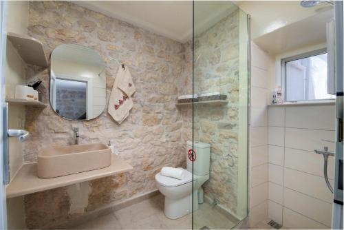 La salle de bains est pourvue de toilettes, d'un lavabo et d'un miroir. dans l'établissement Pavlos, à Gaios