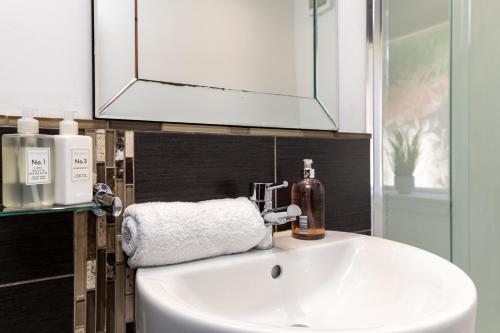 a bathroom sink with a mirror and a towel at Stunning, Remodelled Cottage, Picturesque Location in Duncanston