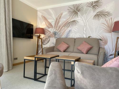 a living room with a couch and two tables at Ermitage de l'Oasis & Spa - Cannes Mandelieu in Mandelieu-la-Napoule