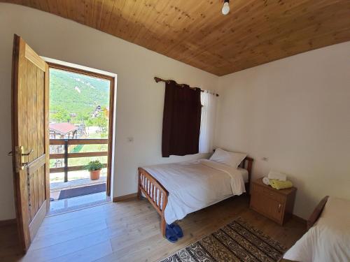 una camera da letto con un letto e una grande finestra di Guest House Flodisa a Theth
