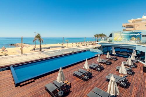 a resort with a swimming pool and a beach at Dom Jose Beach Hotel (Plus) in Quarteira