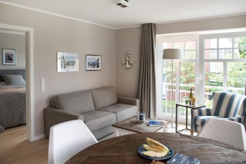 a living room with a couch and a table at Landhaus Lindenhof, Wohnung Meertied in Wangerooge