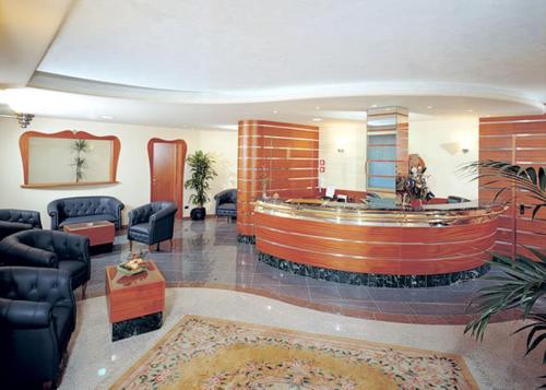 a lobby with a waiting room with chairs and a table at Residence Queen in Rimini