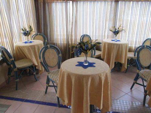 a room with two tables and chairs with flowers on them at Abbadia in San Vito lo Capo