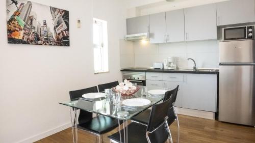 een keuken met een tafel en stoelen en een koelkast bij Apartamentos Pedro for Families by Bedzy in Albufeira