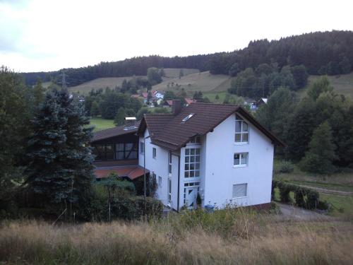 una casa blanca en medio de un campo en Ferienwohnung Am Lindenrain, en Mossautal