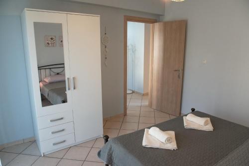 a bedroom with a bed and a dresser with a mirror at BeautyBlue in Kavala