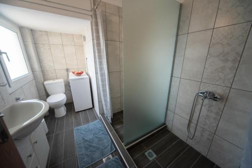 a bathroom with a shower and a toilet and a sink at BeautyBlue in Kavala