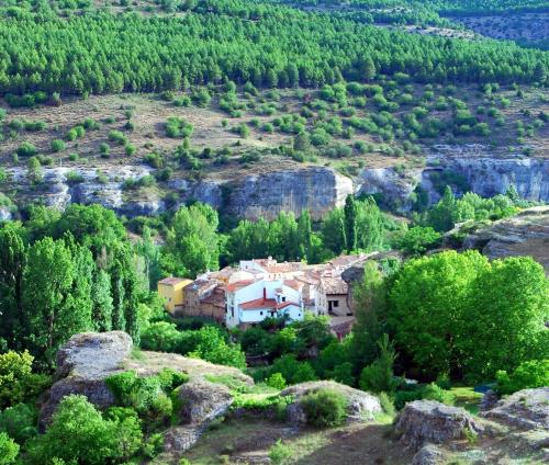 a house on a hill with trees and rocks at Biosfera Suites in Palomera