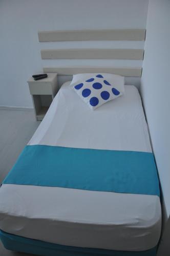 a bed with a blue and white pillow on it at Hotel Nisa in Kas