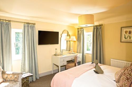 a bedroom with a bed with a desk and a mirror at The Old Mill in Lymington