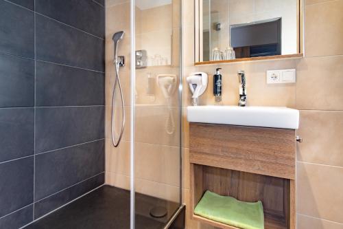 a bathroom with a sink and a shower at Hotel Wettiner Hof in Riesa