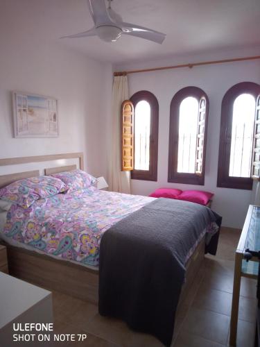 a bedroom with a bed in a room with windows at Marrakesh in Los Alcázares
