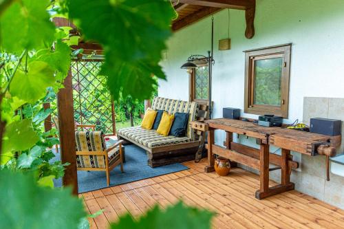 a porch with a couch and a wooden table at Puckó Family in PerÅ‘csÃ©ny