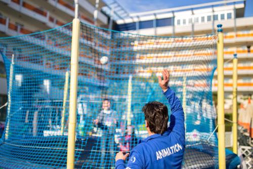a man is reaching up to hit a volleyball at Bibione Palace Hotel in Bibione