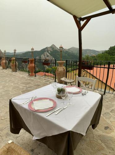 a table with a white table cloth and plates and silverware at Monserrat in Castelmezzano