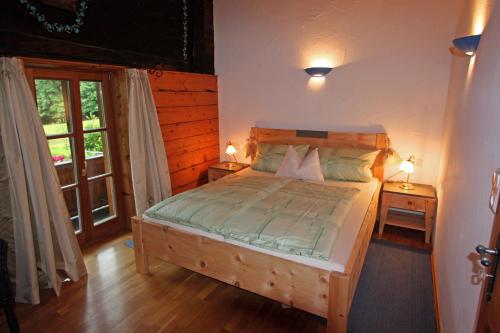 um quarto com uma cama de madeira e 2 mesas de cabeceira em Ferienwohnungen Haus Waldwinkel em Aschau im Chiemgau