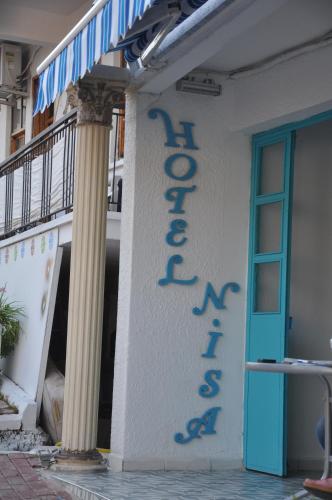 a sign on the side of a building with a blue door at Hotel Nisa in Kas