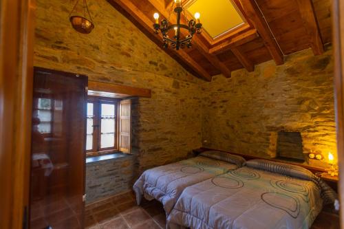 a bedroom with a bed in a stone room at Vivienda Vacacional Casa Fidel in Campas