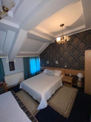 Un dormitorio con una cama blanca y una lámpara de araña. en Motel Zoka, en Dvorovi