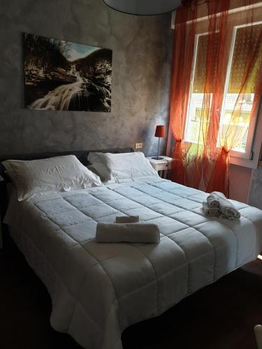 a bedroom with a large white bed with towels on it at hotel Bologna in Fanano