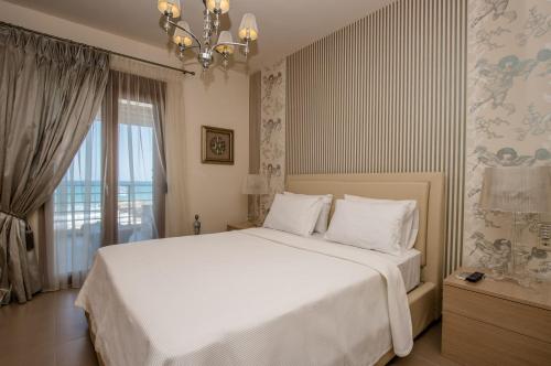 a bedroom with a large white bed and a window at White Crystal Beachfront Apartment in Gournes