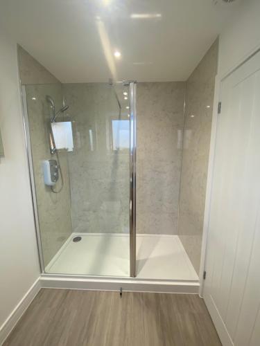a shower with a glass door in a bathroom at Hidden Gem within the City Walls in Canterbury