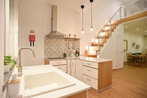 a kitchen with a sink and a staircase at Dabneys Studio in Horta