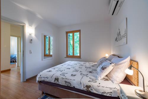a white bedroom with a bed and a desk at Casa Bamboo in Banjole