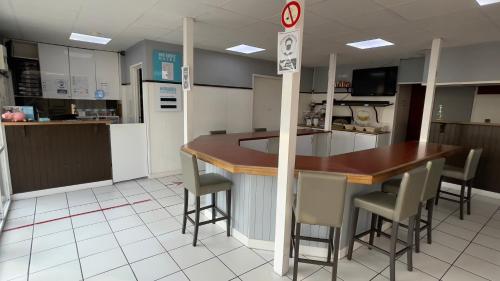 a kitchen with a counter and a bar with stools at Kyriad Direct Val de Reuil in Val de Reuil
