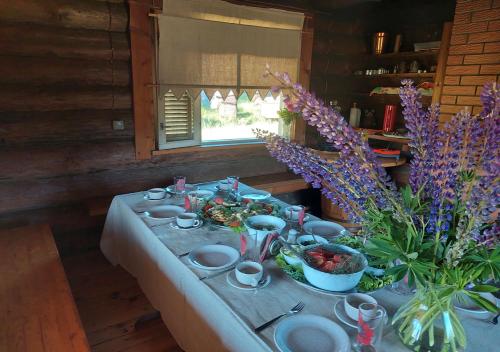 a table with plates of food and flowers on it at Mesikamäe puhkemaja in Põlva