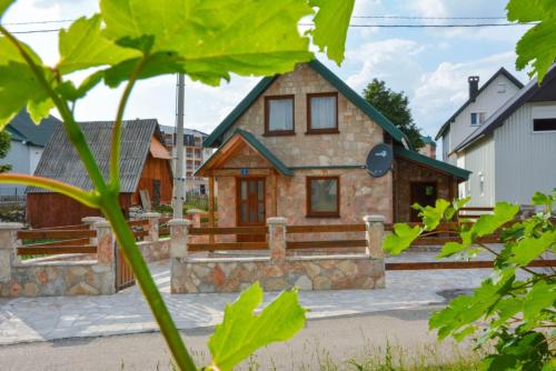 Ein Haus mit einem Steinhaus mit einer Veranda in der Unterkunft Guesthouse MG in Žabljak