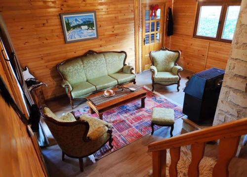 a living room with a couch and chairs and a table at Guesthouse MG in Žabljak