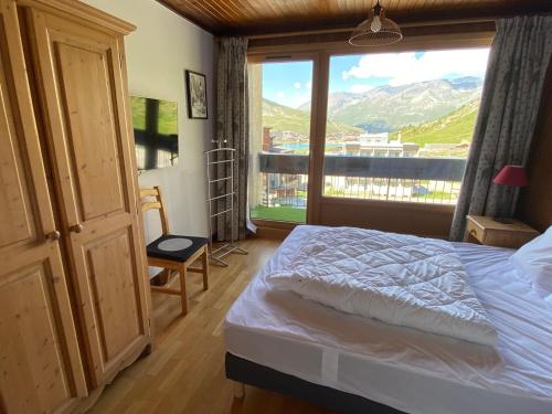 une chambre avec un lit et une grande fenêtre dans l'établissement Tignes duplex 8-10 p avec parking, à Tignes