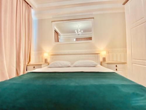 a bedroom with a large bed with a green floor at DeLight Apartments in Boryspilʼ