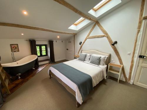 a bedroom with a bed and a bath tub at Maison Mûrier in Fayssac